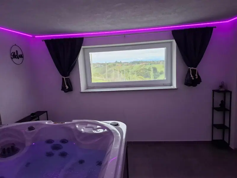 Wellness prostor z jacuzzijem, ambientno osvetlitvijo in razgledom skozi okno
